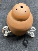 A terracotta floor lamp on iron stand