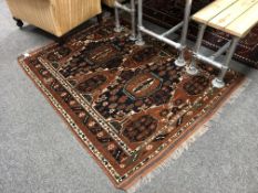 An Afghan Bokhara rug on rust ground,