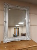 A chrome swept framed mirror,