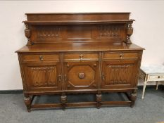 An early 20th century carved oak buffet backed sideboard,