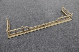 A Victorian brass fire curb