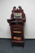 An Edwardian glazed door music cabinet on shaped legs and mirror back above