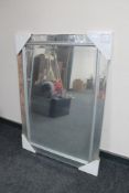 A contemporary all glass framed bevelled edge mirror