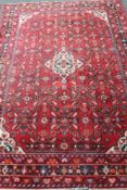 A woollen Persian rug on red ground