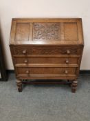 An early 20th century carved oak bureau,
