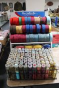 A Berisfords ribbon stand with ribbons together with a plastic crate of a large quantity of buttons