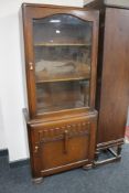 A 1930's oak glazed door cabinet with cupboard beneath