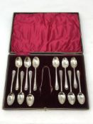 A cased harlequin set of twelve Edwardian silver teaspoons and sugar tongs, various marks.