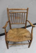 An early 20th century rush seated kitchen armchair