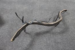 A contemporary figure of two wooden snakes on branch