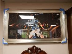 A framed print of a footballer in blue,