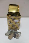 A metal tin of pre decimal British coins and foreign coins