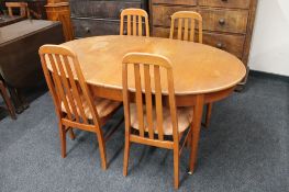 A twentieth century oval teak extending dining table and four chairs