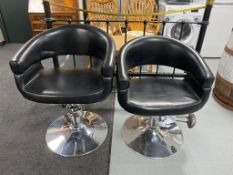 A pair of hydraulic salon armchairs