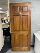 A wooden exterior door with brass fixtures