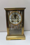 A brass and glass cased anniversary clock with brass and enamelled dial,