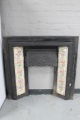 An antique cast iron tiled fire insert