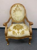 A large traditional style gilded armchair,