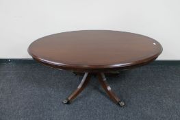 An oval inlaid mahogany pedestal coffee table together with matching nest of three tables