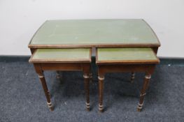 A mahogany glass topped coffee table fitted two tables beneath