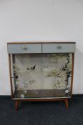A mid century sliding glass door display cabinet together with a mid century blanket box