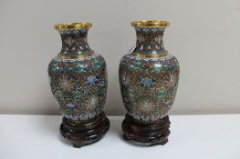 A pair of cloisonne vases on wooden stands, height 14.