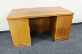 A mid 20th century teak twin pedestal desk