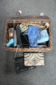 A wicker basket containing a collection of lady's handbags