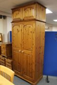 A pine double door wardrobe with top box