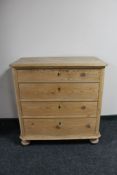 An antique stripped pine four drawer chest