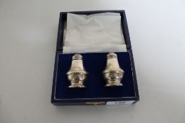A boxed pair of silver salt and pepper sifters