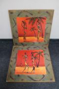 A pair of framed wall art panels depicting African figures