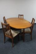 A teak G Plan drop leaf table and four rail back chairs