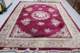 A Chinese floral embossed carpet on maroon ground