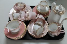 A tray of decorative pink lustre tea china