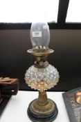 A glass and brass oil lamp CONDITION REPORT: Crack to reservoir. Chimney good.