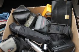 A box of assorted cameras including Kodak, Pentax, Praktica, binoculars,