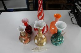 A tray of decorative coloured glass jugs and vases