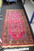 A Persian rug on raspberry ground,