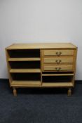 A set of blonde oak shelves fitted three drawers