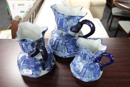 A set of three graduated blue and white Staffordshire style jugs