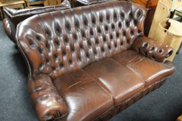 A three piece brown leather chesterfield style lounge suite