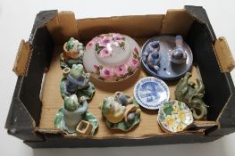 A box containing decorative china frog figures,
