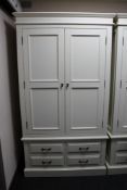 A contemporary white double door wardrobe fitted with four drawers