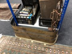 An antique brass fender together with a cast iron three piece companion set on stand