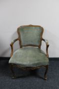 An antique style carved walnut armchair in green fabric