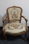 An antique style carved walnut armchair in tapestry fabric