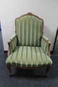 A carved walnut framed striped armchair