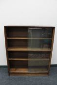 A teak sliding door bookcase
