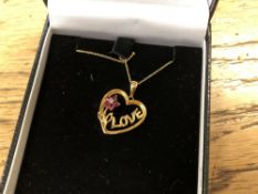 A yellow gold ruby and diamond set heart pendant